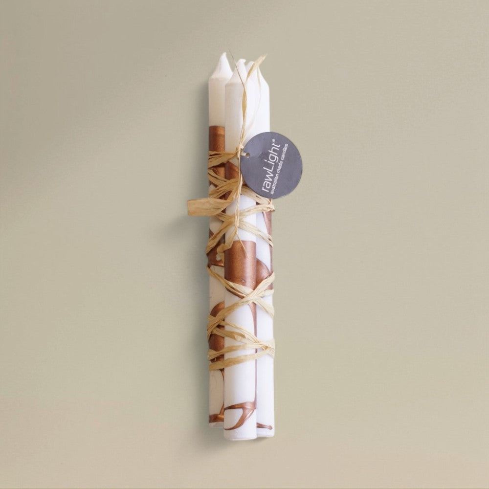 Three white-and-copper splashed Christmas dining candles