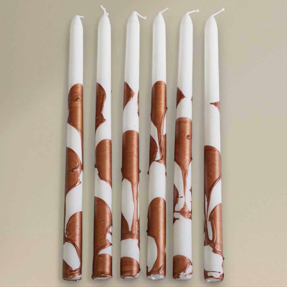 Six white-and-gold splashed Christmas taper candles